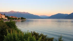 Serene Lake Garda waterfront at golden hour with mountain backdrop, Mediterranean vegetation, calm water reflecting sky, no text or signage visible