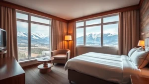Cozy hotel room interior with mountain view windows, modern furnishings, comfortable bed with white linens, warm lighting, and mountain landscape visible through windows
