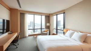 Modern hotel room with minimalist Japanese design, clean lines, neutral tones, comfortable bed with premium linens, floor-to-ceiling windows overlooking Kyoto cityscape, contemporary furniture, no visible text or signage