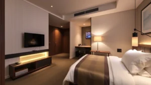 Modern hotel room interior with contemporary Japanese design, comfortable bed with white linens, desk workspace, flat-screen TV, warm ambient lighting, compact efficient layout, no visible text or signage